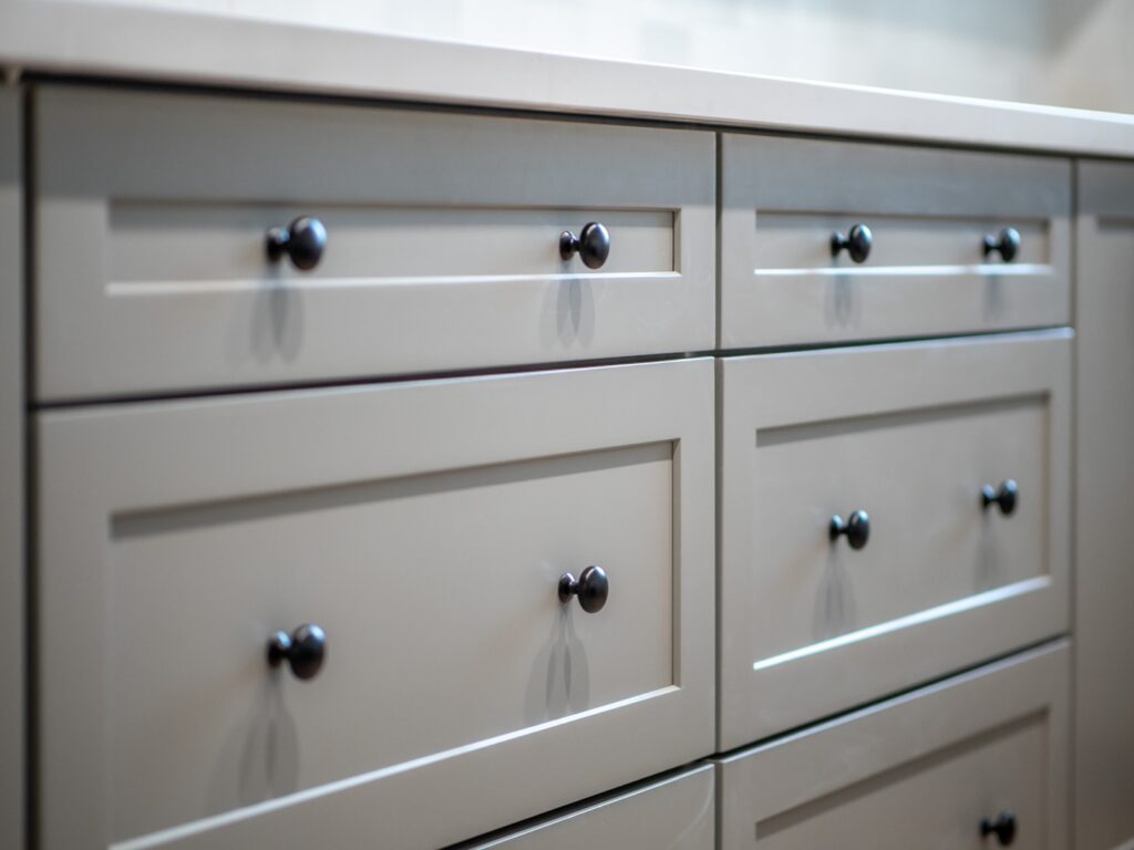 Gray kitchen cabinets with double knob placement on drawers
